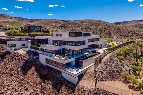 An Aerial View Of A Modern Home In The Desert With Mountains And Blue