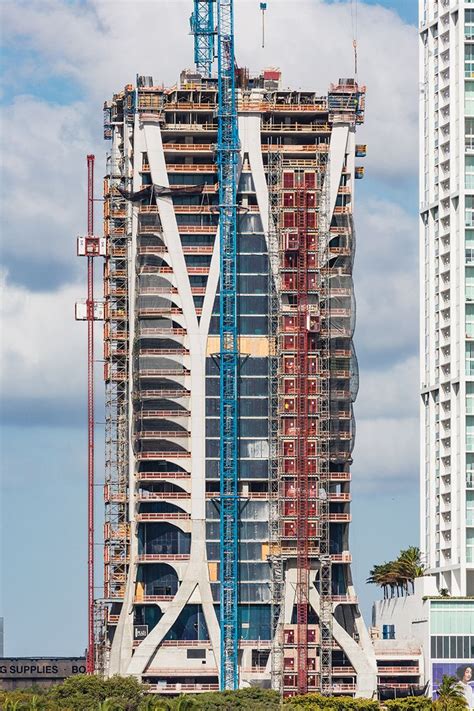 The Tall Building Is Under Construction In Front Of Other Buildings On