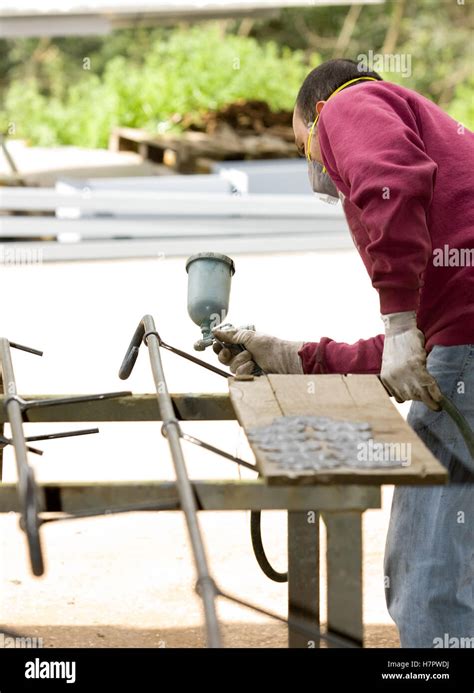 Craftsman Painting An Iron Gate With A Spray Machine Stock Photo Alamy