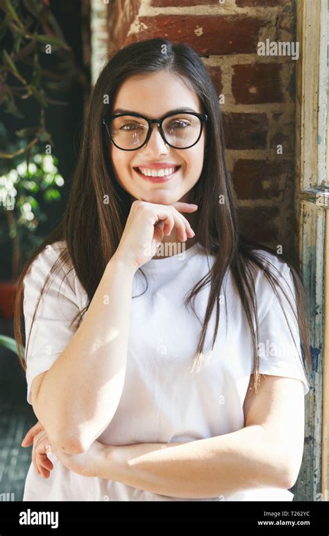 Portrait Of Brunette Longhaired Woman Wearing Glasses Smiling Near The