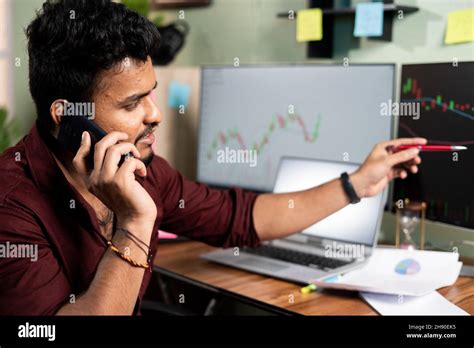 Stock Broker Discussing About Equity Shares With Client On Mobile Phone