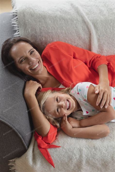 Front View Of Caucasian Mother And Daughter Relaxing Together On A Sofa