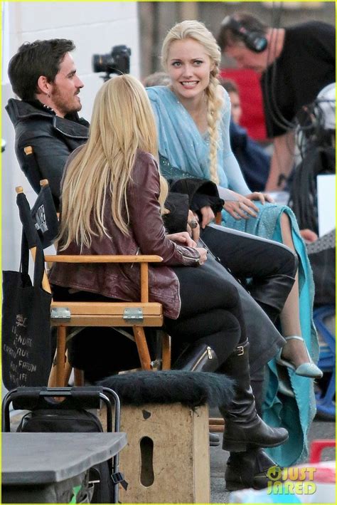 The Blonde Woman Is Sitting In A Chair With Two Other People