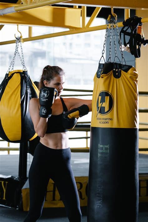 Woman With Boxing Gloves Hitting Punching Bag · Free Stock Photo