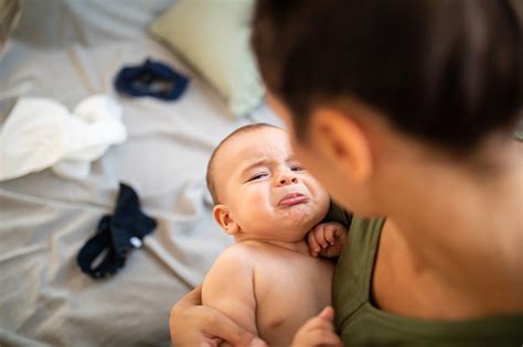 Crying Baby Boy In Mothers Arms Stock Photo Download