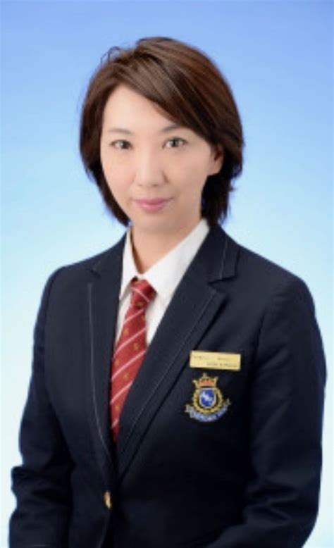 A Woman Wearing A Suit And Tie Posing For A Photo In Front Of A Blue