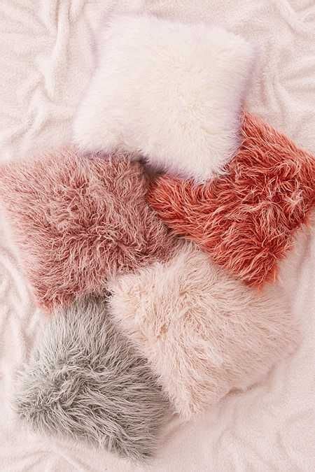 An Image Of Some Fur Pillows On A Bed