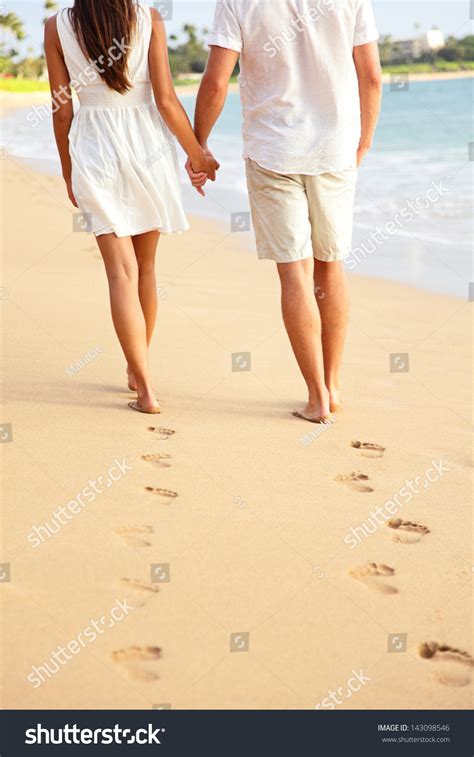 Couple Holding Hands Walking Romantic On Beach On Vacation Travel Holidays Leaving Footprints In