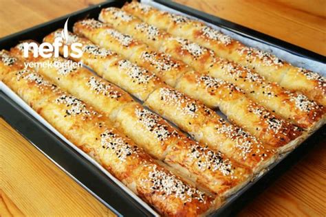 Bread Sticks Are Lined Up In A Baking Pan On A Wooden Table With The