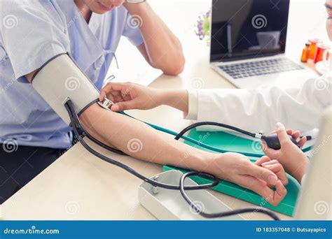 Doctor Using Sphygmomanometer With Stethoscope Checking Blood Pressure