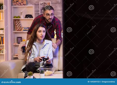 Boyfriend Helping His Girlfriend To Play Video Games On Television