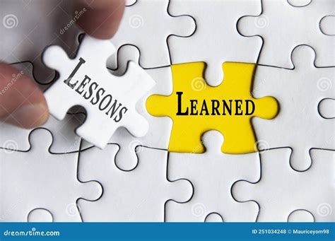 Lessons Learned Text On Jigsaw Puzzle With One Hand Holding A Missing