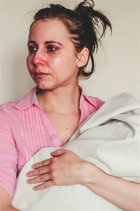 Portrait Of A Crying Young Mother Holding Her Baby On White Background