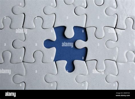 White puzzle with missing piece on blue background, top view. Career