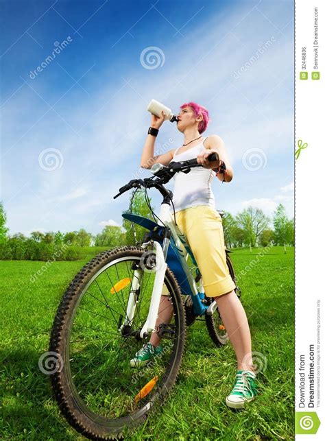 Young Woman On A Bike Drinking Water Royalty Free Stock