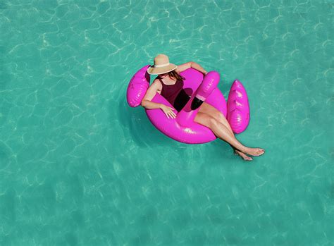 Top View Of Woman Floating On Inflatable Pink Flamingo In A Pool