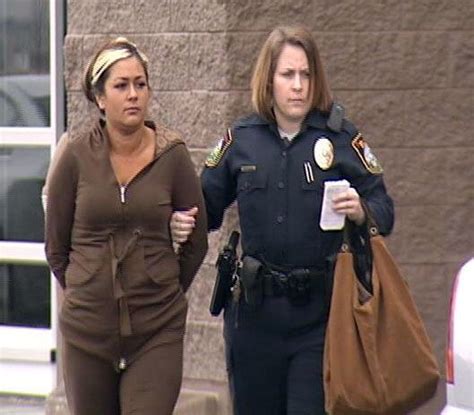 two women walking down the street in front of a police car and one is holding a coffee cup