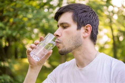 Young Man Is Drinking Water From Bottle At Sunny Hot Day Stock Image