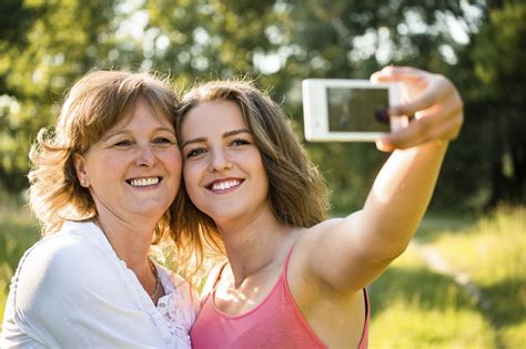 Two Women Mother And Daughter Making Selfie By Smartphone At Park Stock