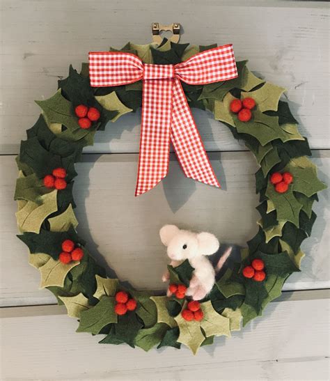 A Christmas Wreath Hanging On The Side Of A Door With A Toy Mouse In