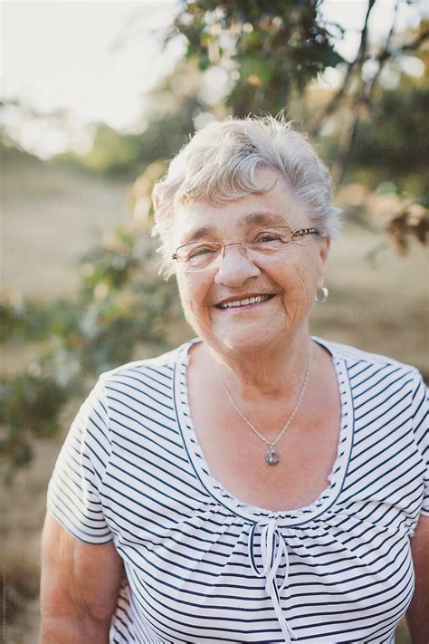 Elderly Woman Smiling In The Sunshine By Stocksy Contributor Rob And