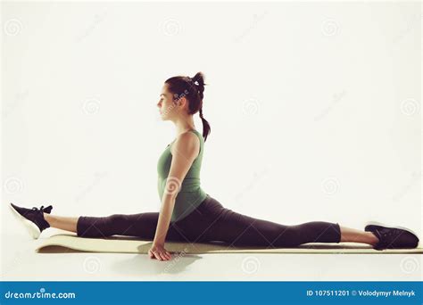 Beautiful Slim Brunette Doing Some Stretching Exercises In A Gym Stock