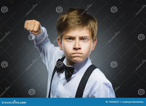 Portrait Of Angry Boy Isolated On Gray Background He Raised His Fist