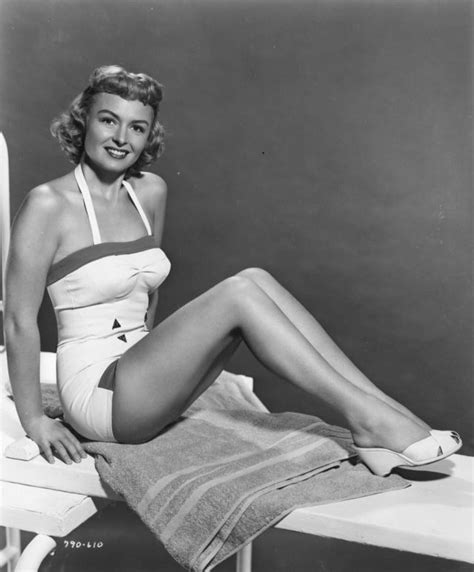 A Black And White Photo Of A Woman In A Bathing Suit Sitting On A Chair