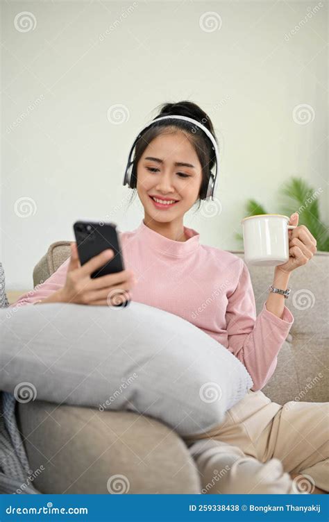 Pretty Asian Girl Chilling In Her Living Room Listening To Music