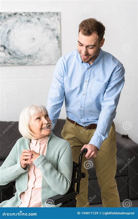 Man Carrying Disabled Senior Mother On Wheelchair Stock Image Image Of Care Diseased 194011129