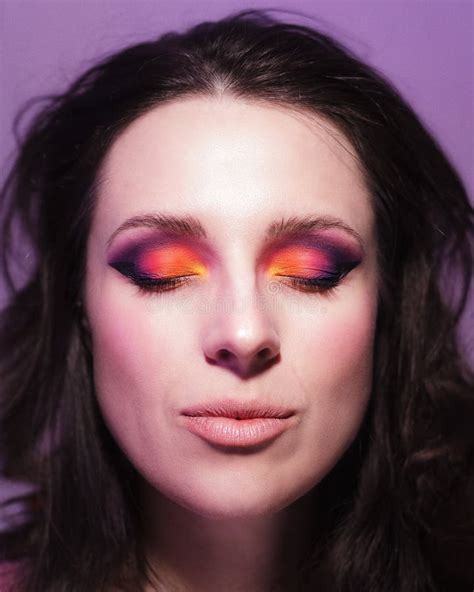 Studio Portrait Of Dark Haired Woman Wearing Bright Makeup In Sunset Colours Stock Photo Image