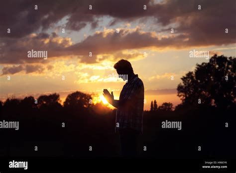Silhouette Of A Man Praying In The Sunset Concept For Religion Worship
