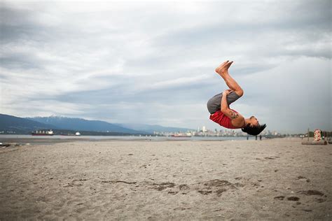Man Doing Back Flip At Beach Photograph By Christopher Kimmel