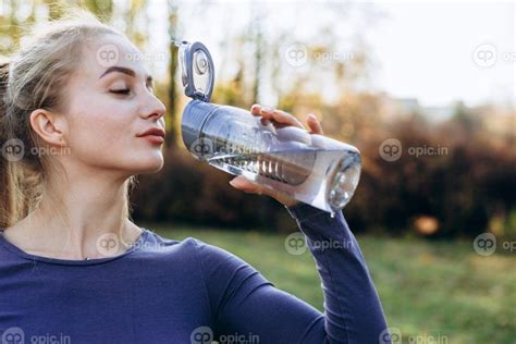 دانلود عکس دختر ورزشی لاغر در حال نوشیدن آب تناسب اندام زن جوان در حال
