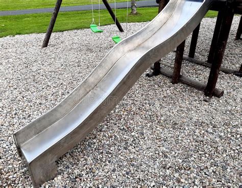 Stainless Steel Slide And Swings On The Playground In The Park In Gray