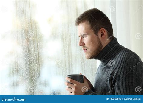 Angry Man Looking Through A Window In A Rainy Day Stock Photo Image