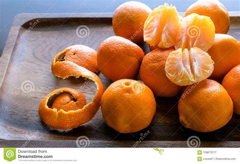 Mandarin Orange Slices With Unpeeled Oranges Background Stock Image
