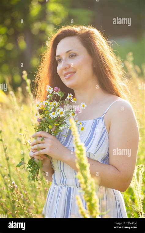 Close Up Portrait Of Beautiful Young Woman Sniffing Bouquet Of