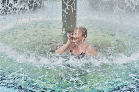 Mature Woman Under Jets Of Water Outdoor Thermal Pool Stock Image