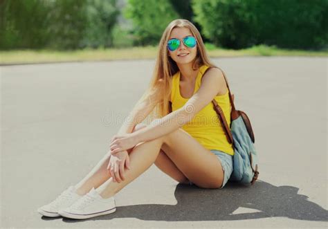Portrait Young Woman Sitting On The Sidewalk In Summer On A Sunny Day