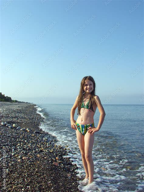 Babe Girl In Bikini Posing On A Deserted Pebble Beach Stock Photo Adobe Stock