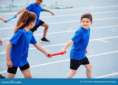 Children In Athletics Team Competing In Relay Race On Sports Day Stock