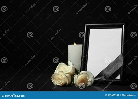 Funeral Photo Frame With Ribbon White Roses And Candle On Dark Table