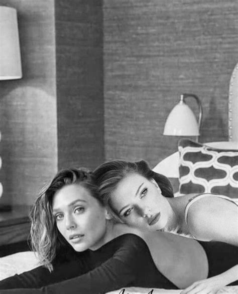 Two Beautiful Women Laying On Top Of A Bed