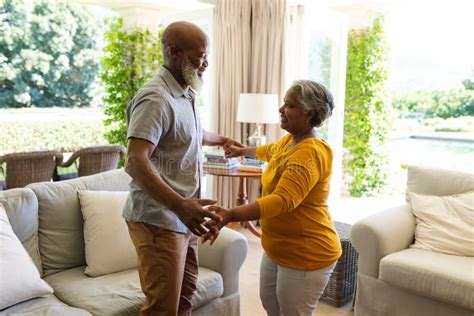 Senior African American Couple Dancing Together In Living Room Smiling