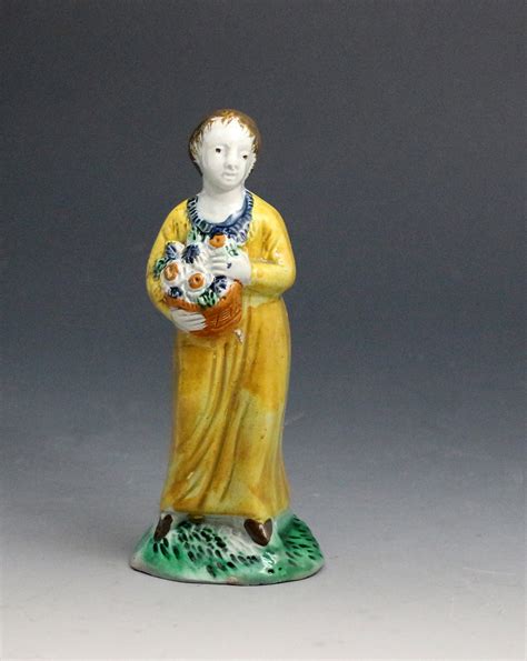 Staffordshire Pottery Figure Of A Girl Holding A Basket Of Flowers Late