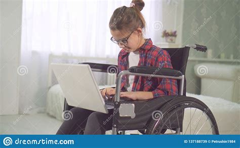 Portrait Of A Teenage Disabled Girl In A Wheelchair Using