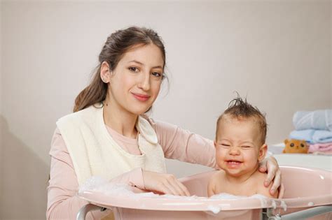 Madre Joven Y Feliz Bañándose Lavando Al Bebé En Baño De Burbujas Madre