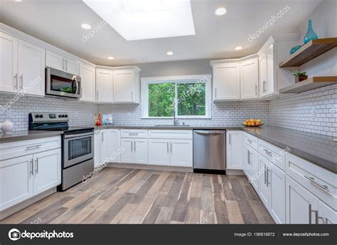 Islands add function and space to a room. Open Concept Kitchen White Cabinets Grey Quartz Countertops Tile Backsplash — Stock Photo ...