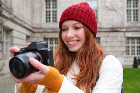 Redhead Girl Photographer Takes Photos On Professional Camera Outdoors